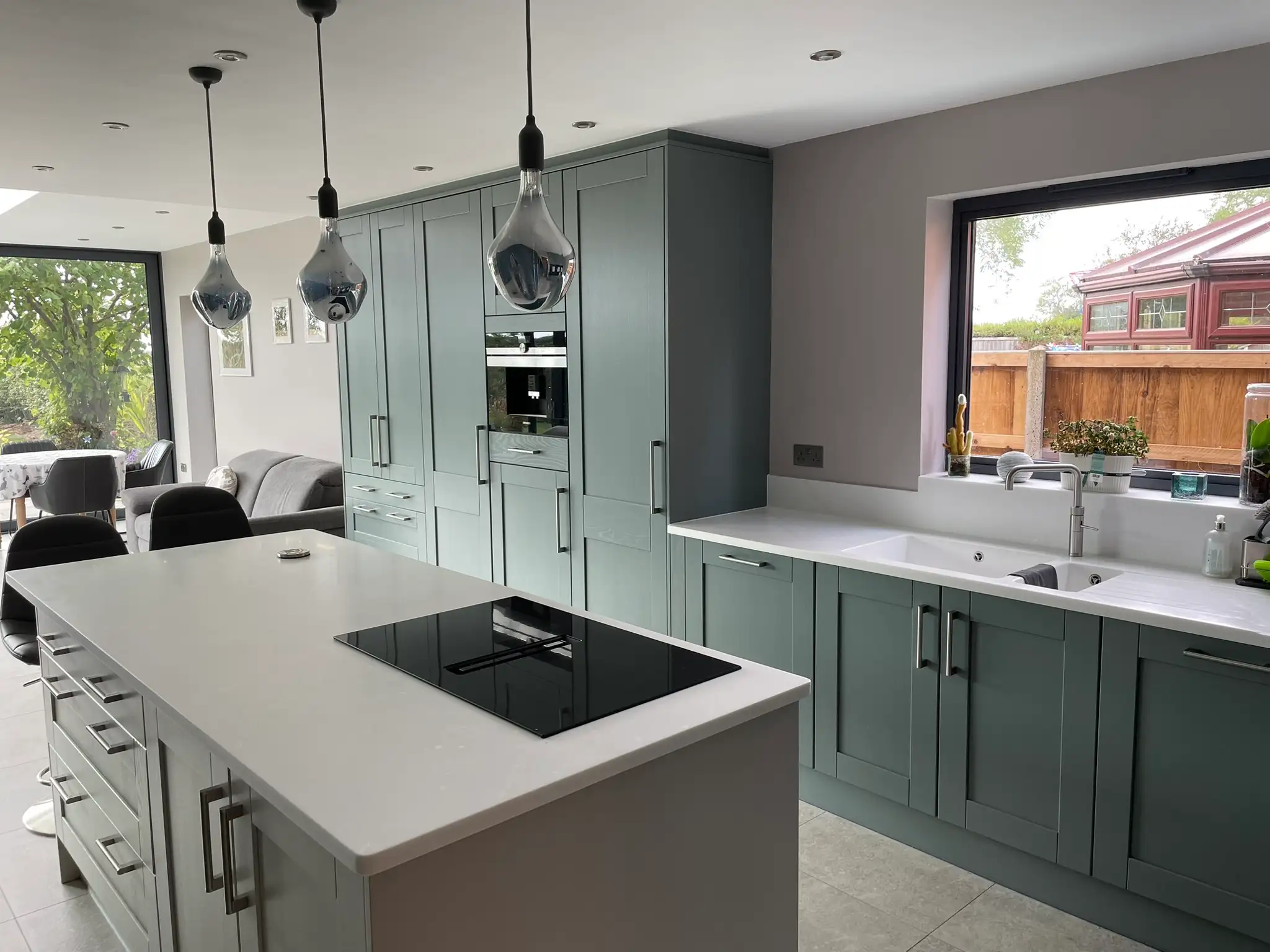 Sage green shaker kitchen with pendant lighting